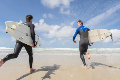 Surfers racing to the sea