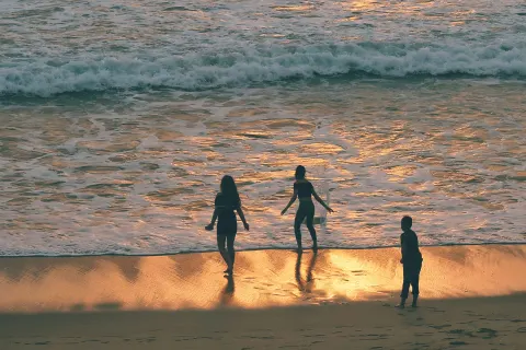 Image destinations-north-cornwall-newquay-fistral-1762792944 for Family playing in the waves at sunset