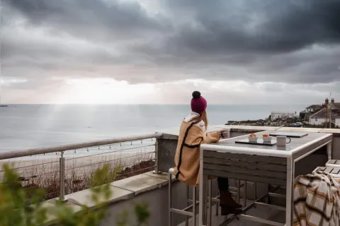 Image a-guide-to-loving-the-rain-in-cornwall-1789562496 for Lady enjoying a coffee before the storm