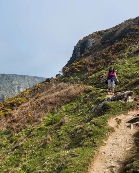Image the-best-coastal-walks-in-cornwall-1781098203 for An image of a woman walking the South West Coast Path, in Tintagel, Cornwall